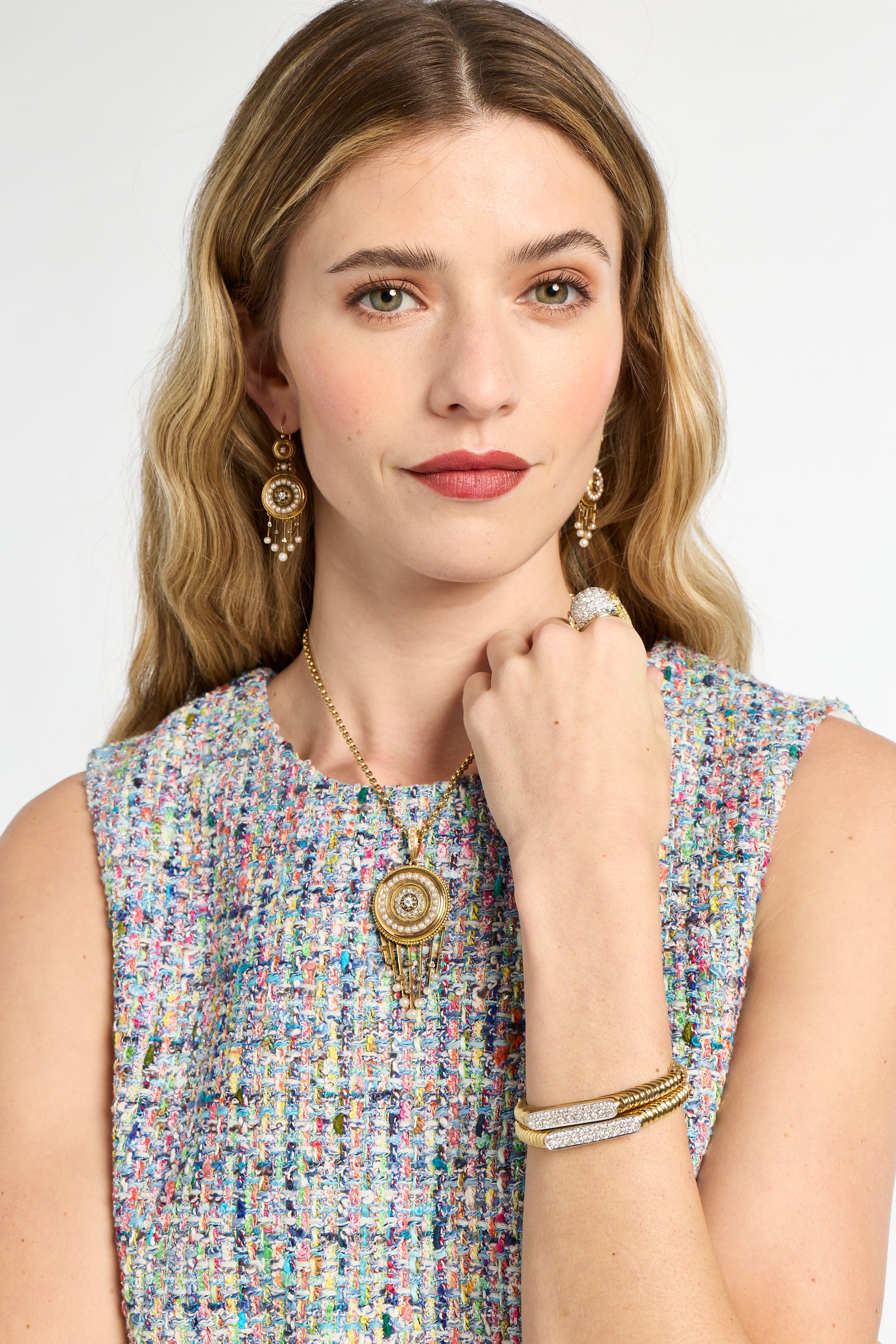Woman wearing jewelry including earrings, a necklace, and bracelets on a white background