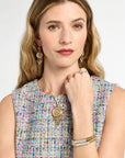Woman wearing jewelry including earrings, a necklace, and bracelets on a white background