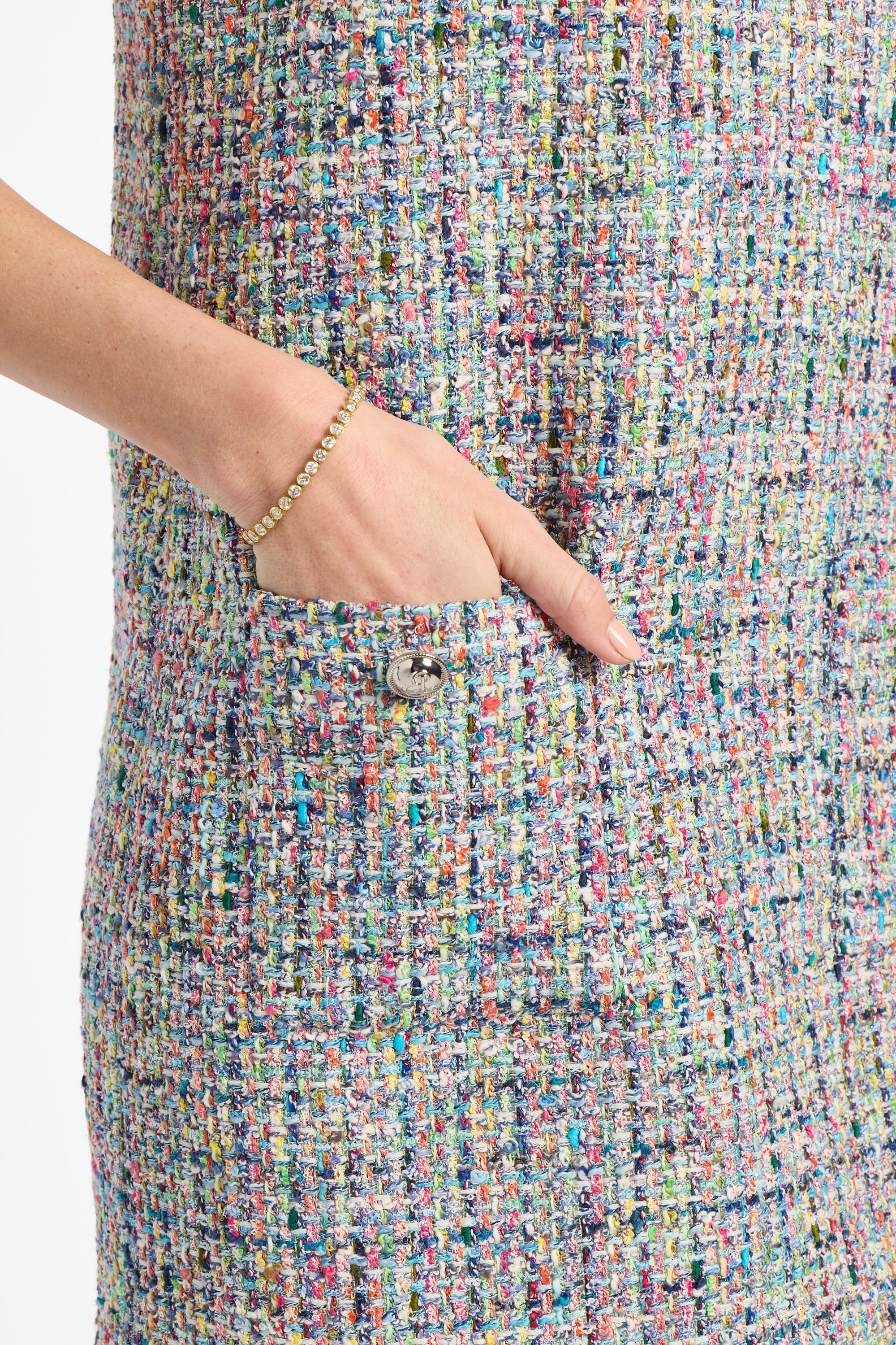 Multicolored textured fabric with a hand pointing to a button