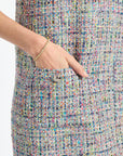 Multicolored textured fabric with a hand pointing to a button