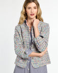 Woman wearing a multicolored blazer over a striped shirt on a white background