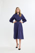 Woman wearing a navy dress with a belt on a white background