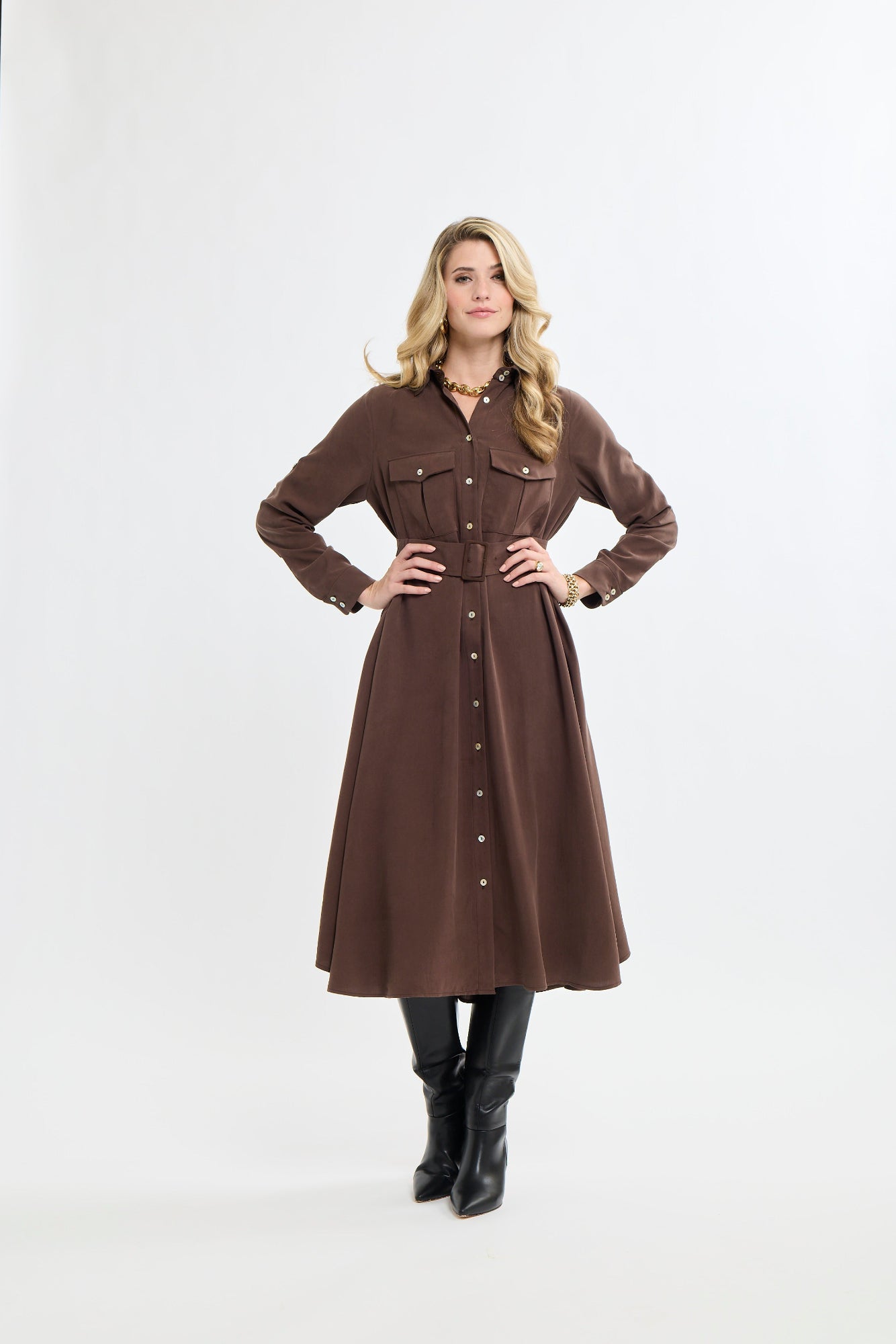 Woman wearing a brown dress with buttons on a white background
