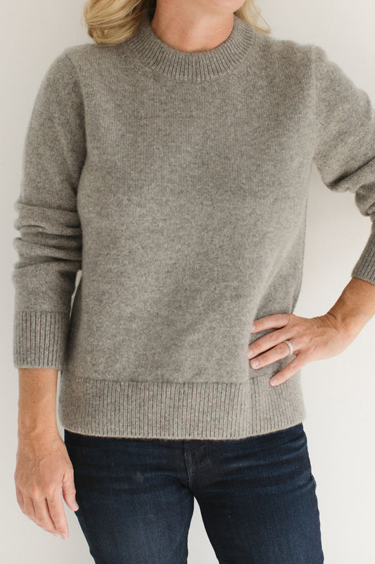 Eleanor Leftwich wearing the Gray Classic Cashmere Crew paired with dark jeans, standing against a white minimalistic background.