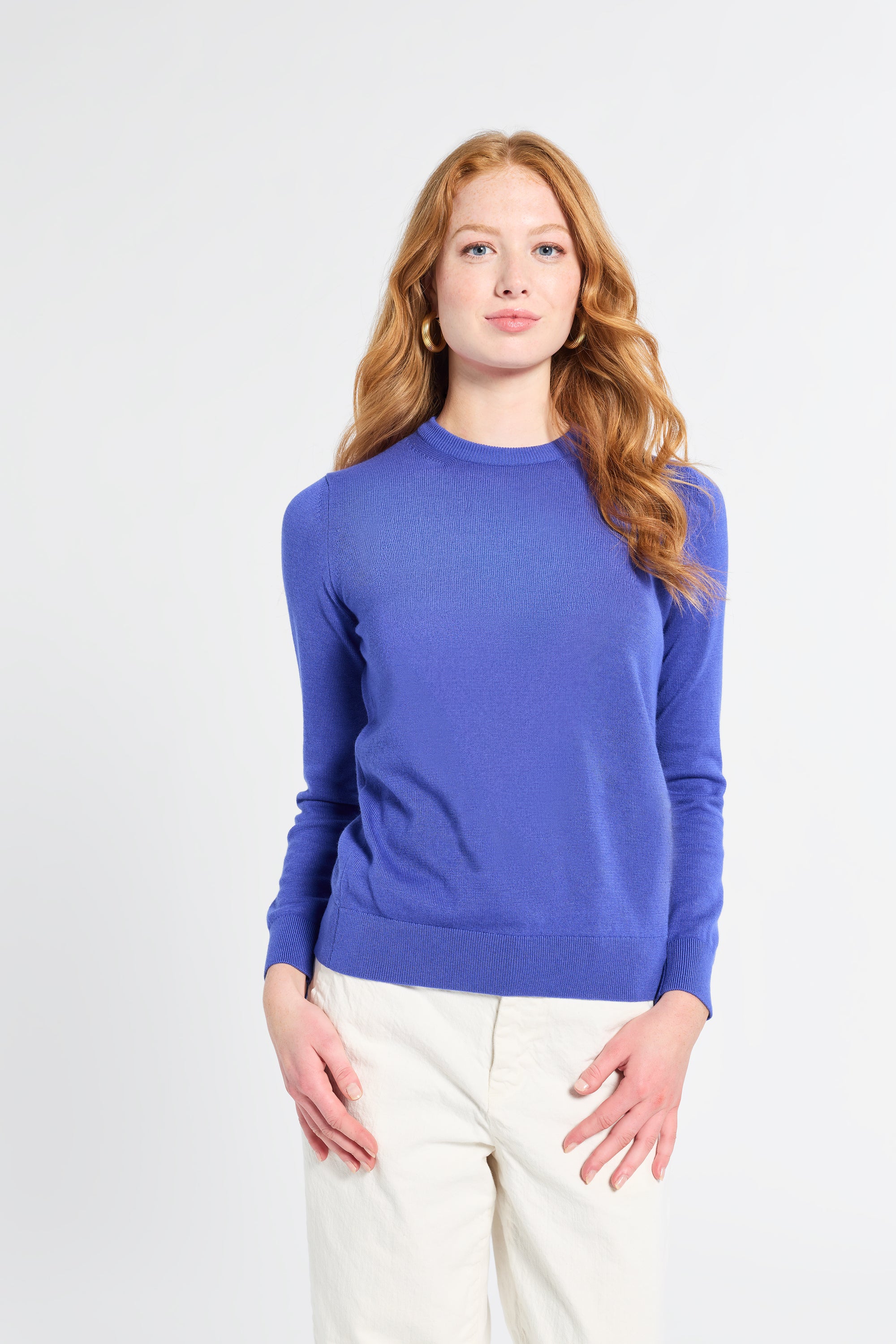 Woman wearing a royal blue sweater on a white background