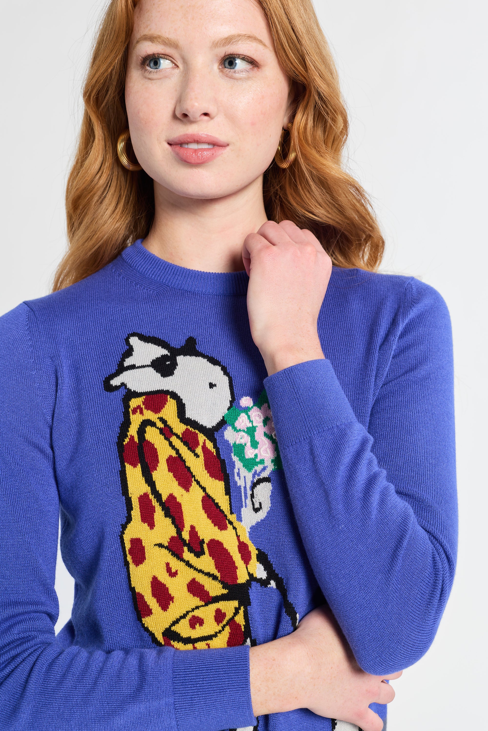 woman wearing a blue sweater with a colorful graphic design on a white background