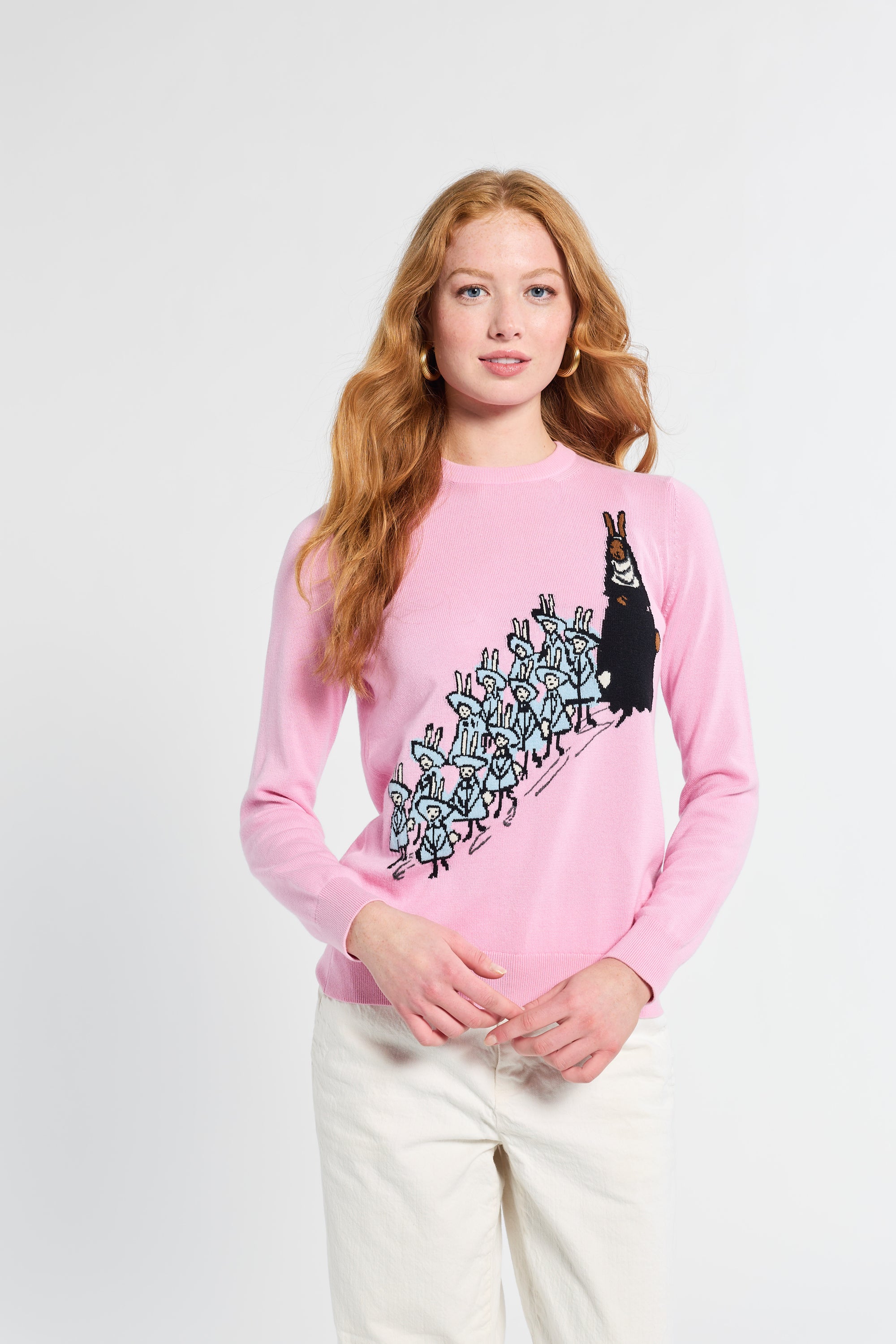 Person wearing a pink sweatshirt with a graphic design on a white background