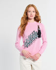 Person wearing a pink sweatshirt with a graphic design on a white background
