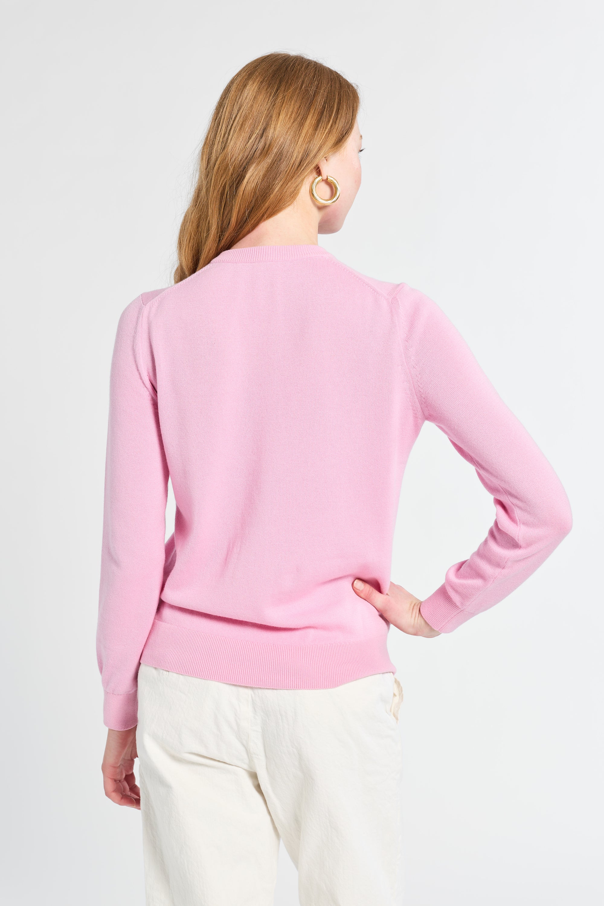 Woman wearing a pink sweater on a white background