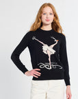 Woman wearing a black sweater with a graphic design of a ballerina on a white background