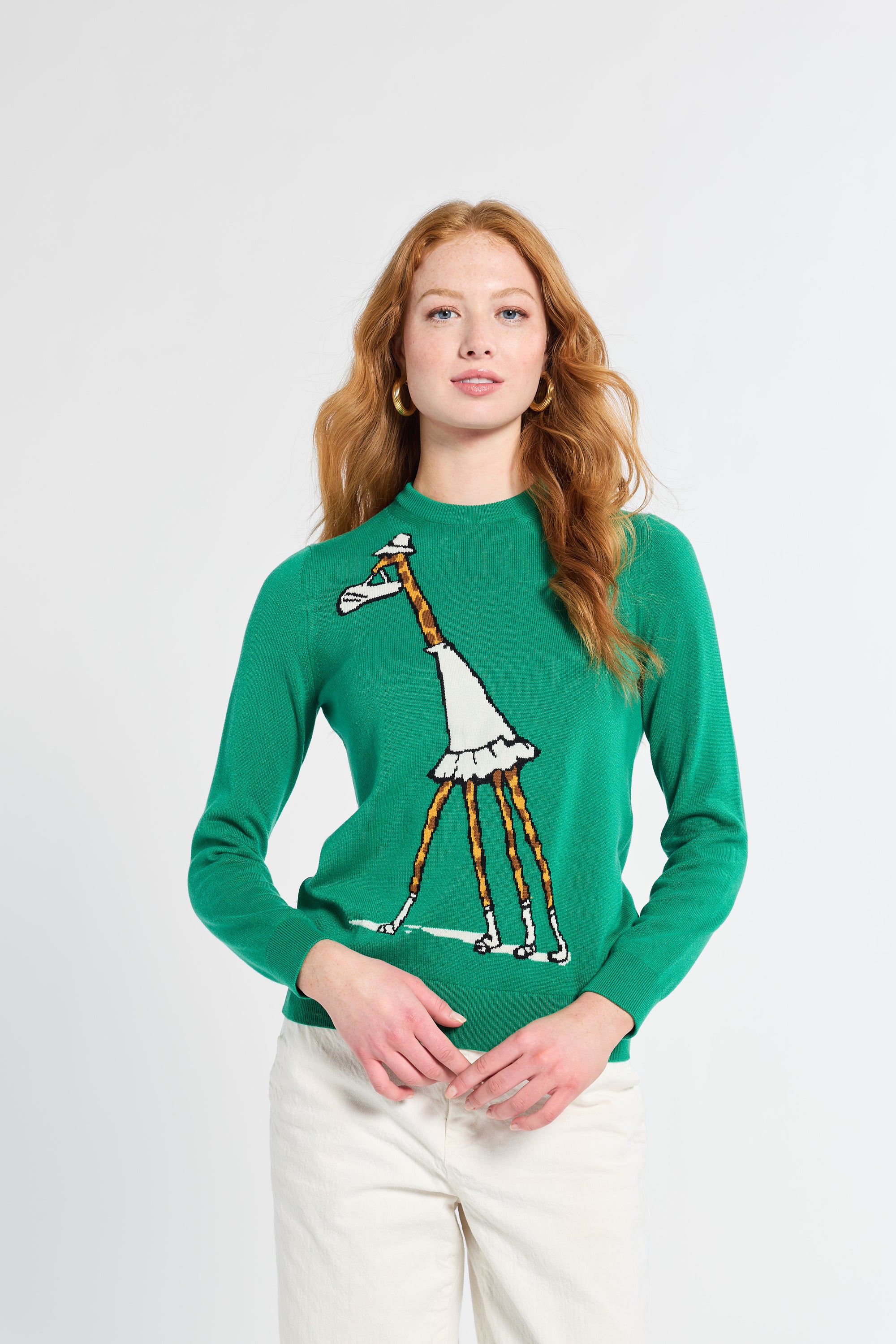 Woman wearing a green sweater with a giraffe design on a white background