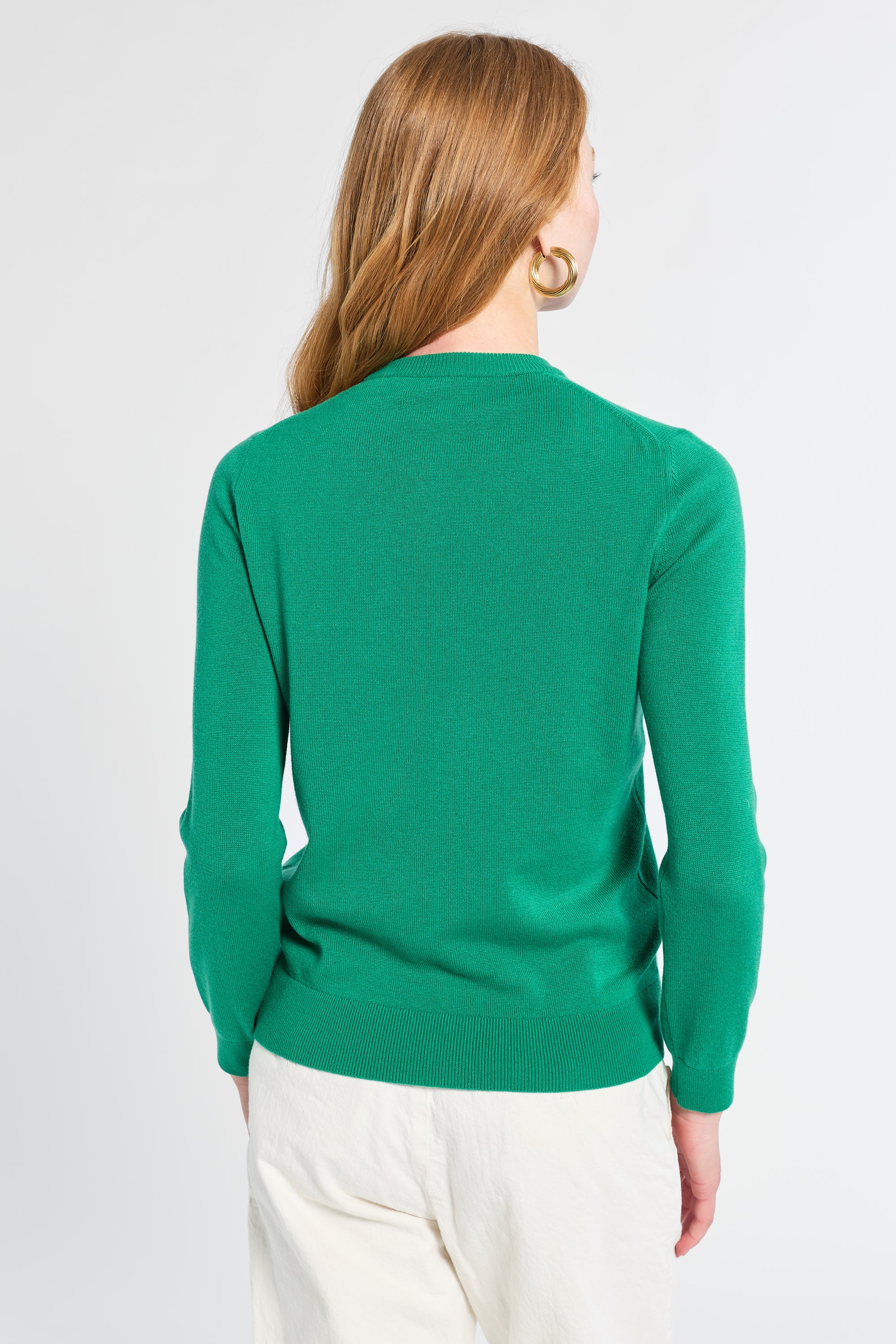 Person wearing a green sweater on a white background