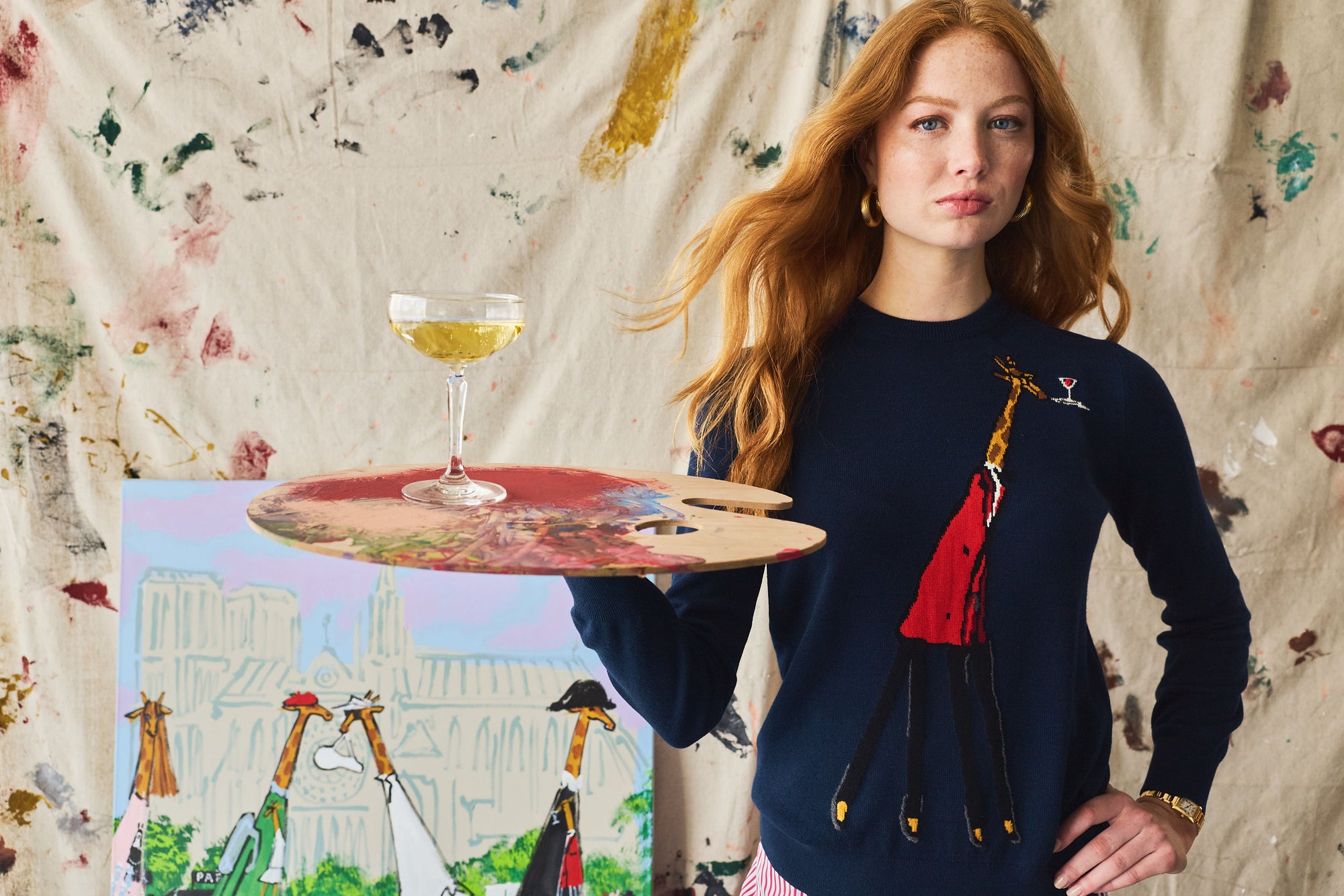 Woman holding a tray with a glass of yellow liquid, standing against a floral curtain.