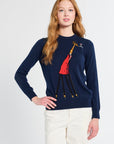 Woman wearing a navy sweater with a colorful giraffe design on a white background
