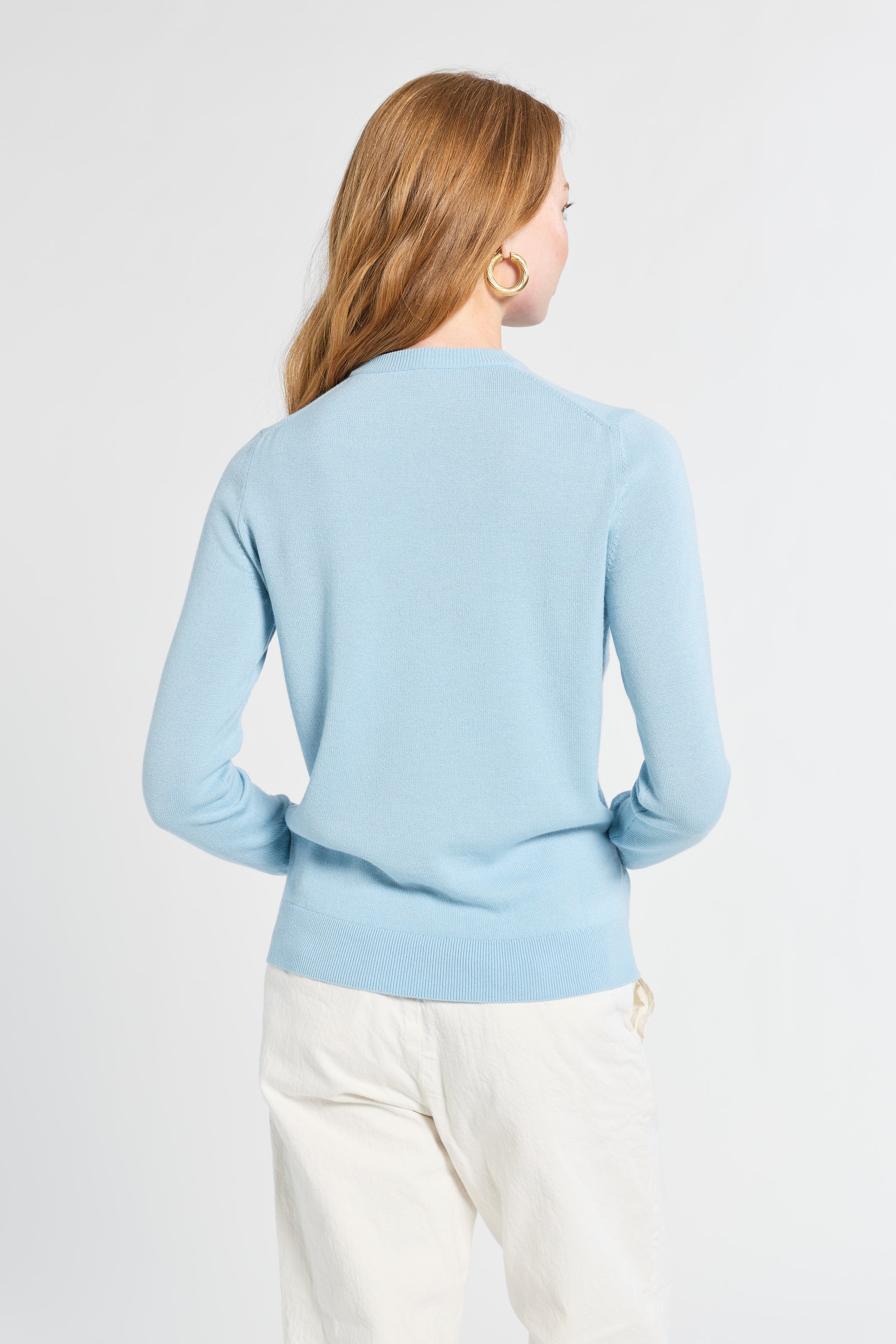 Woman wearing a light blue sweater on a white background