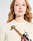 Woman wearing a sweater with a graphic design of a giraffe on a white backdrop.