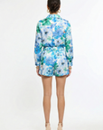 back of woman wearing matching green and blue floral shirt and short set