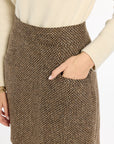 Close-up of the pocket and brown woven texture of the Tobacco Tweed Meg Mini Skirt, photographed against a plain white studio background.