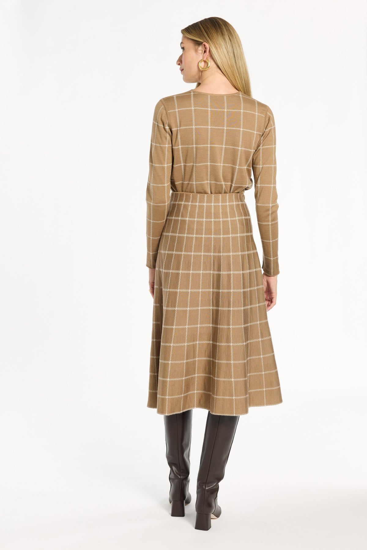 A woman modeling the chestnut side of the Windowpane Plaid Reversible Flared Skirt with the matching crewneck, back view, photographed against a plain white studio background.