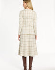 A woman modeling the cream side of the Reversible Knit Jacket with the matching windowpane skirt, back view, photographed against a plain white studio background.