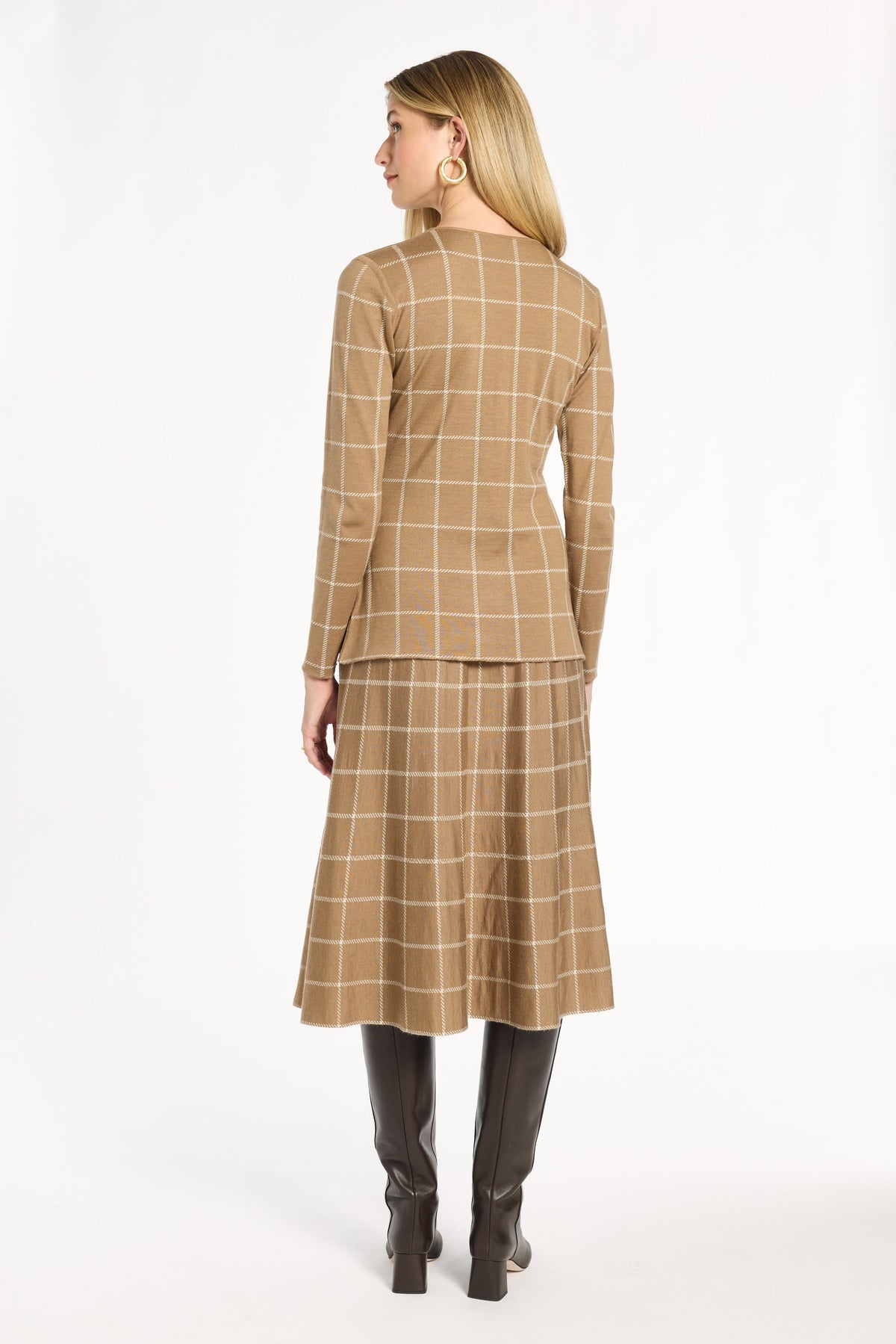 A woman modeling the chestnut side of the Windowpane Plaid Reversible Knit Jacket with the matching skirt, back view, photographed against a plain white studio background.