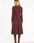 A woman modeling the cranberry side of the Windowpane Plaid Reversible Knit Jacket with the matching skirt, back view, photographed against a plain white studio background.