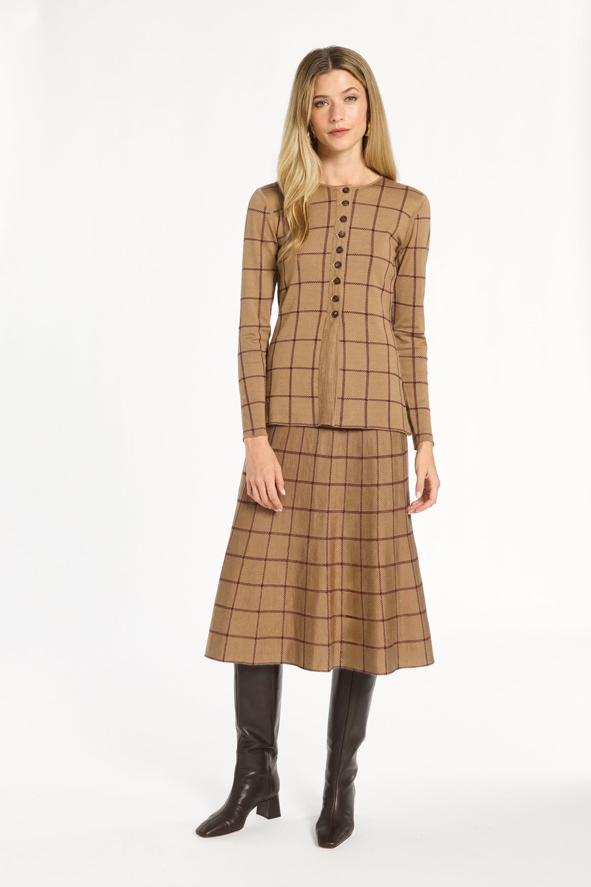 A woman modeling the chestnut reverse of the Cranberry Windowpane Plaid Knit Jacket with the matching skirt, front view, photographed against a plain white studio background.