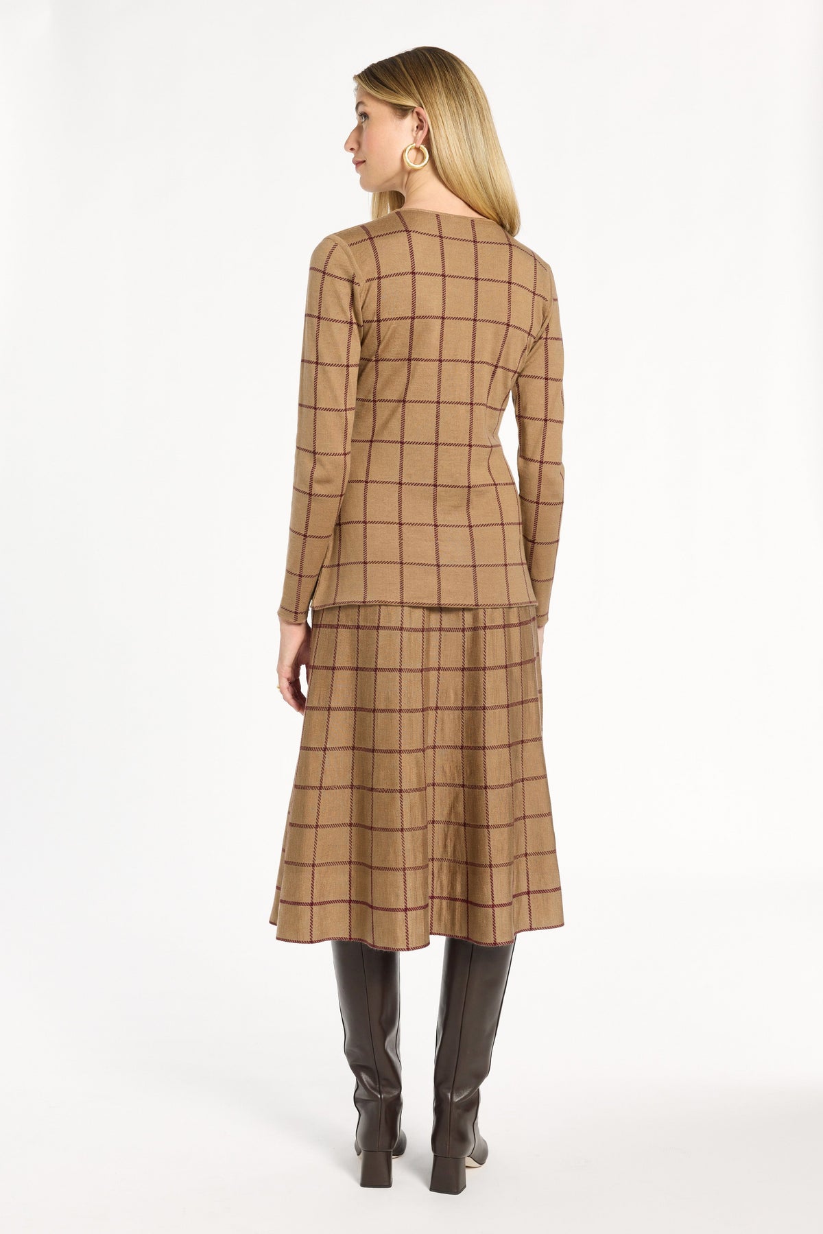 A woman modeling the chestnut reverse of the Cranberry Windowpane Plaid Knit Jacket with the matching skirt, back view, photographed against a plain white studio background.