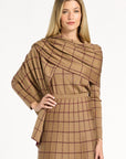A woman modeling the chestnut reverse of the Cranberry Windowpane Plaid Wrap draped over the matching skirt and crewneck, front view, photographed against a plain white studio background.