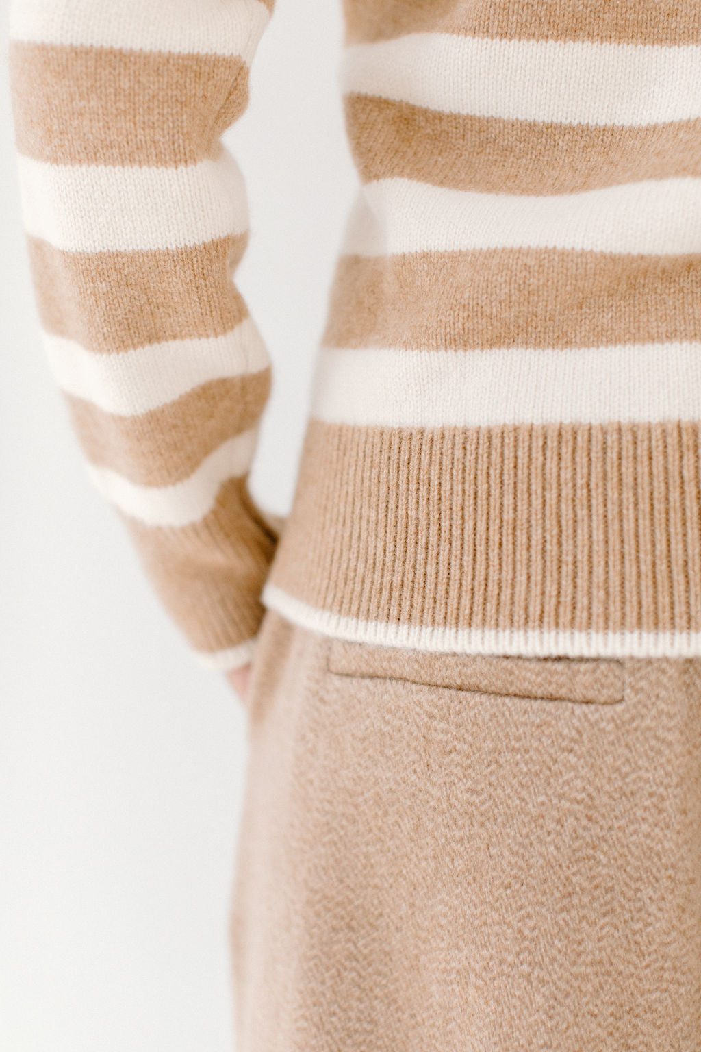 Close-up detail of the camel/cream Classic Striped Cashmere Crew, paired with camel trousers, highlighting the soft texture and fit.