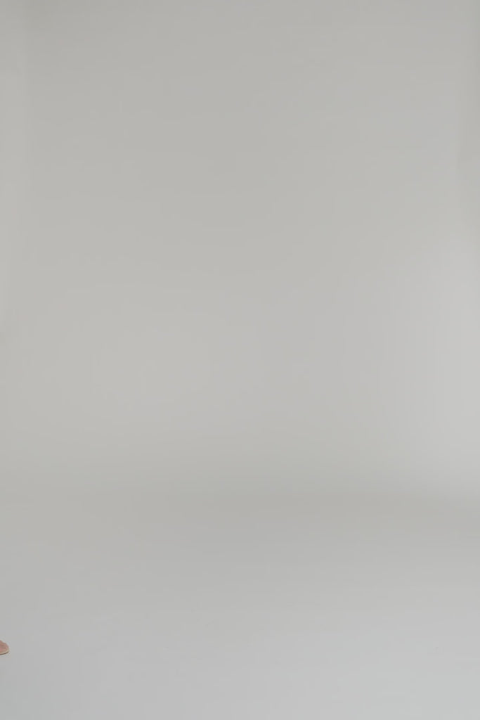 woman modeling a long colorful dress on a white background