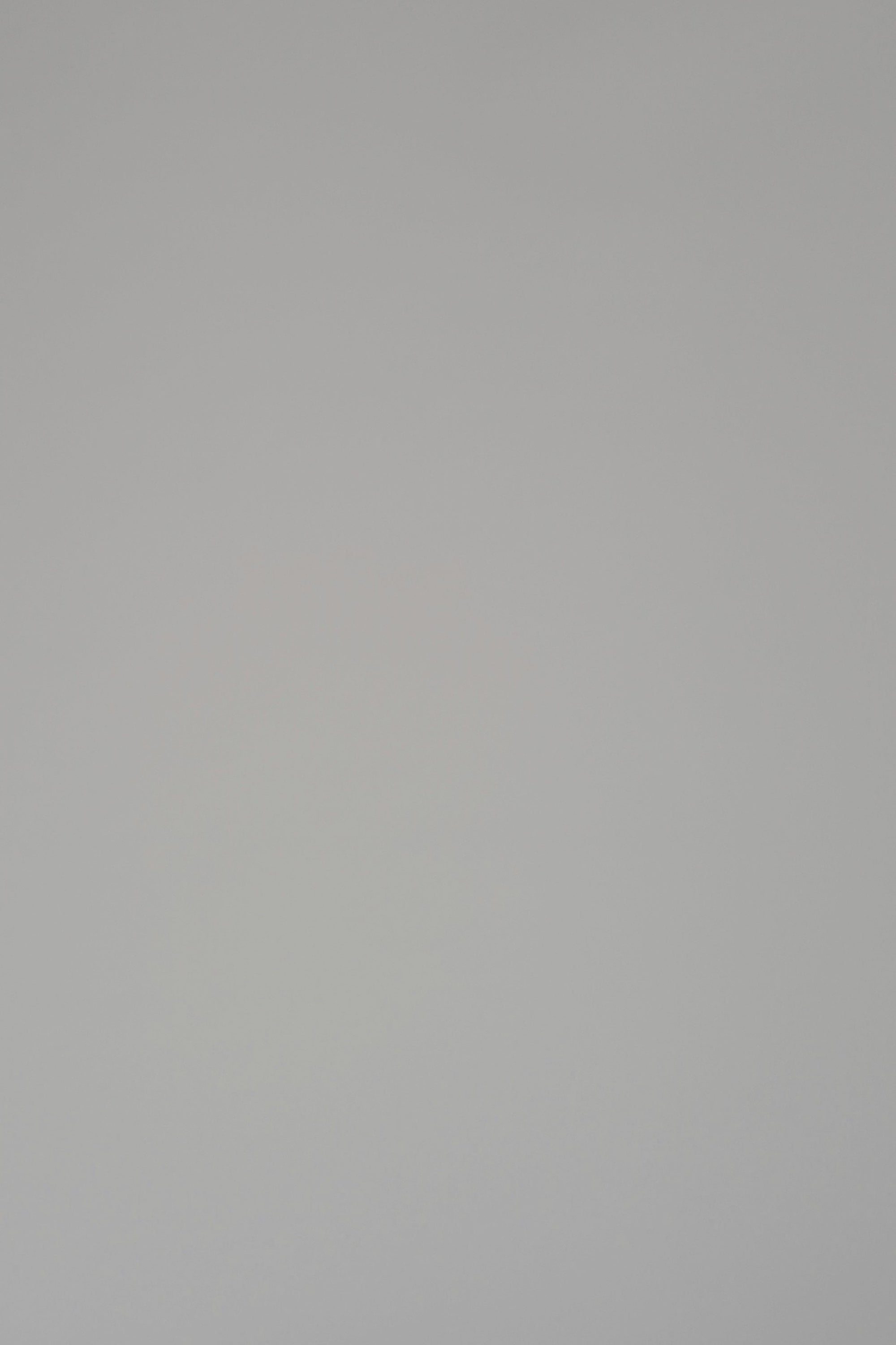 Woman wearing a long sleeve white crewneck on a plain backdrop