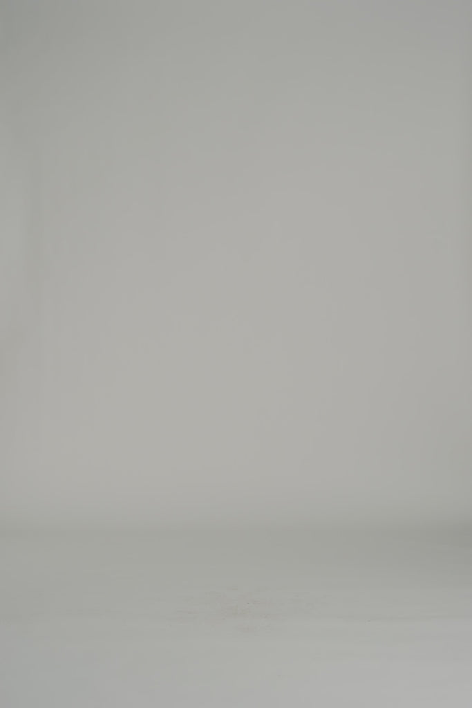 woman modeling a long sleeve white blouse and white pants on a white backdrop
