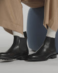 Black Italian made boots tapping on a white studio ground and backdrop