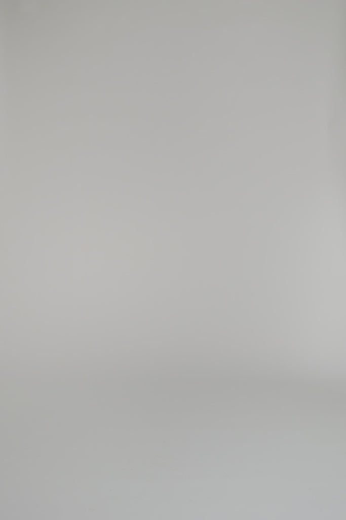 woman modeling a gold and white patterned shirt against a white background