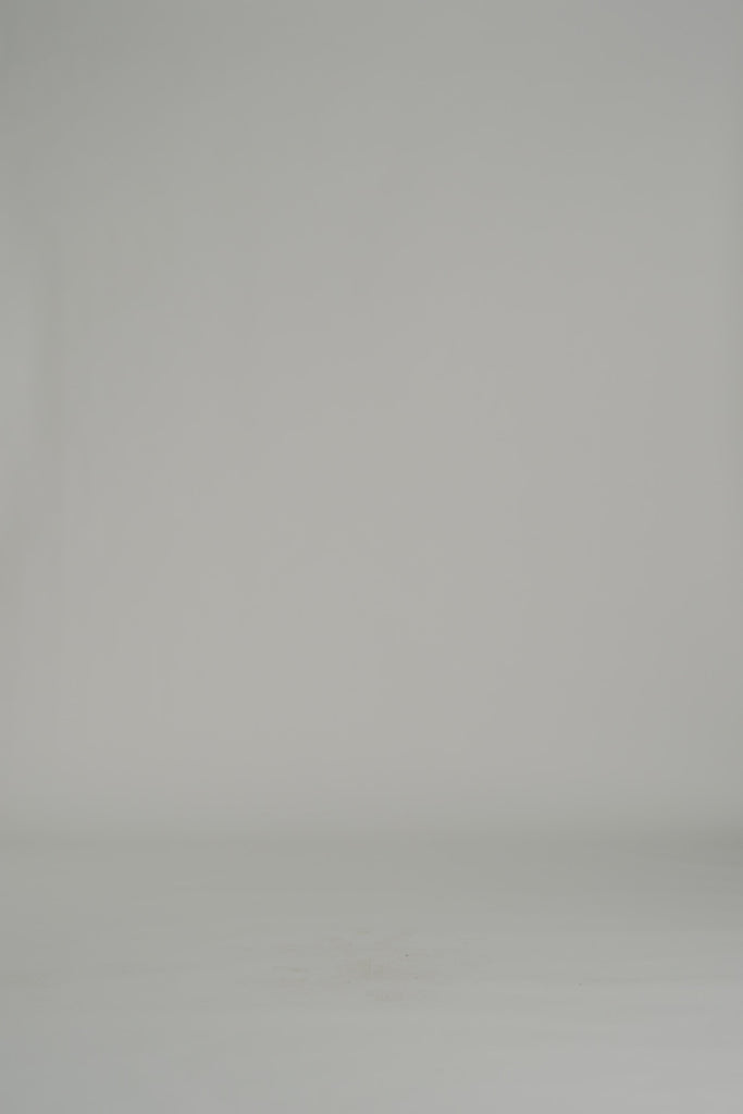 lady modeling a white blouse and white shorts on a white backdrop