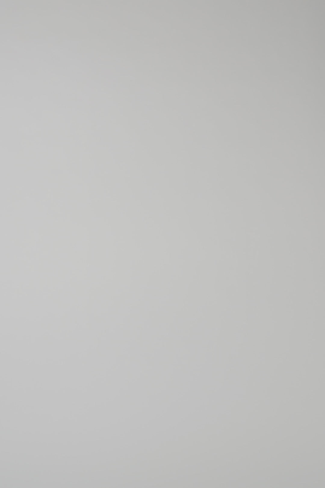 Woman wearing a green knit crewneck on a white backdrop