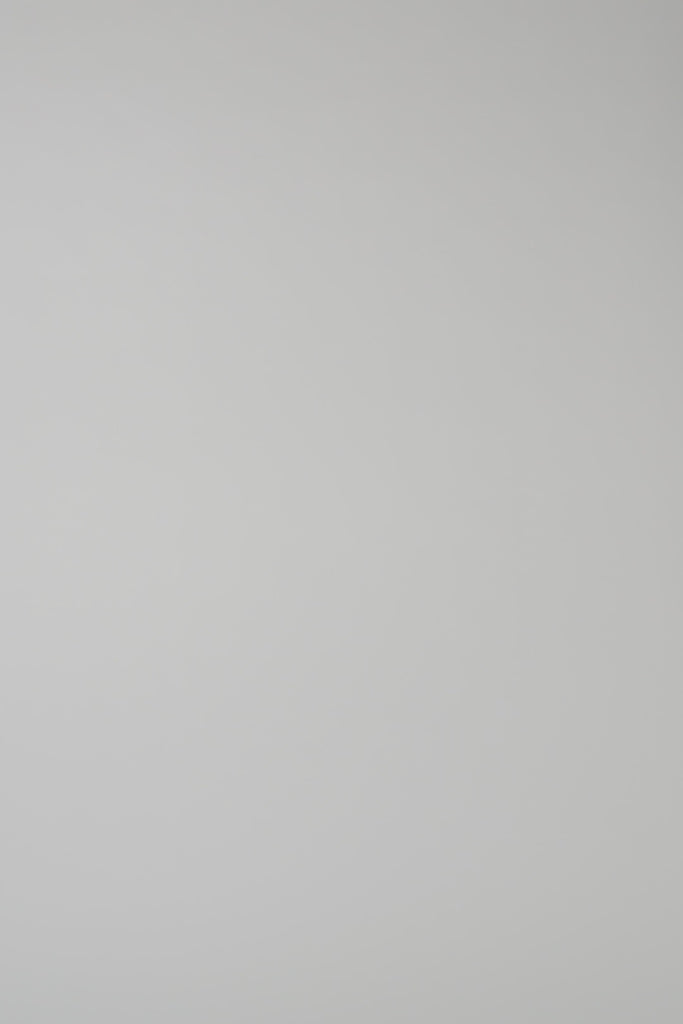 Woman wearing a green knit crewneck on a white backdrop