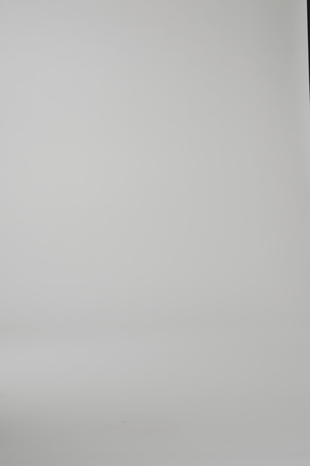 A woman modeling a red cashmere wrap on a light gray studio backdrop
