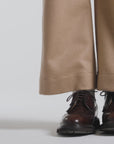 Woman modeling a dark brown pair derby shoes on a white backdrop
