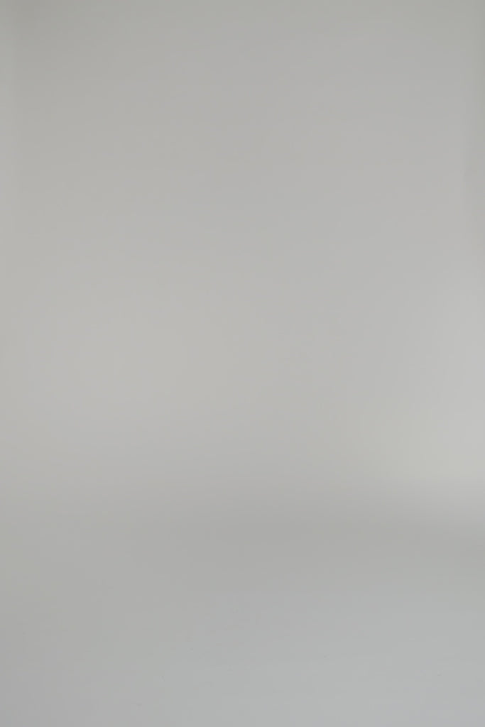 woman wearing blue blouse and shorts set with flats against a white background