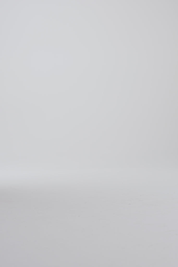Model walking in dark brown derby shoes on a white backdrop