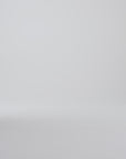 Model walking in dark brown derby shoes on a white backdrop