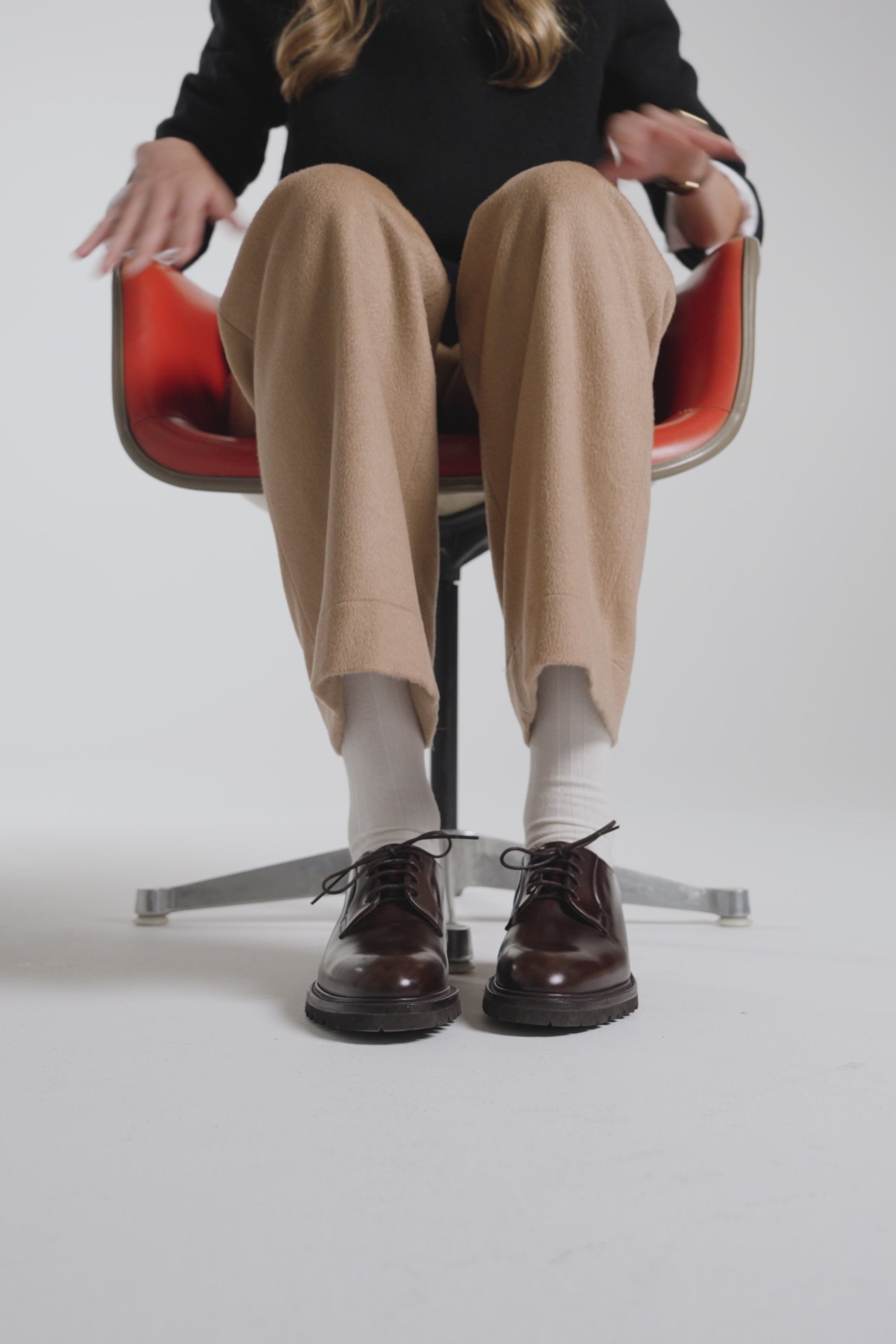 Woman spinning in a chair wearing dark brown derby shoes
