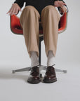 Woman spinning in a chair wearing dark brown derby shoes