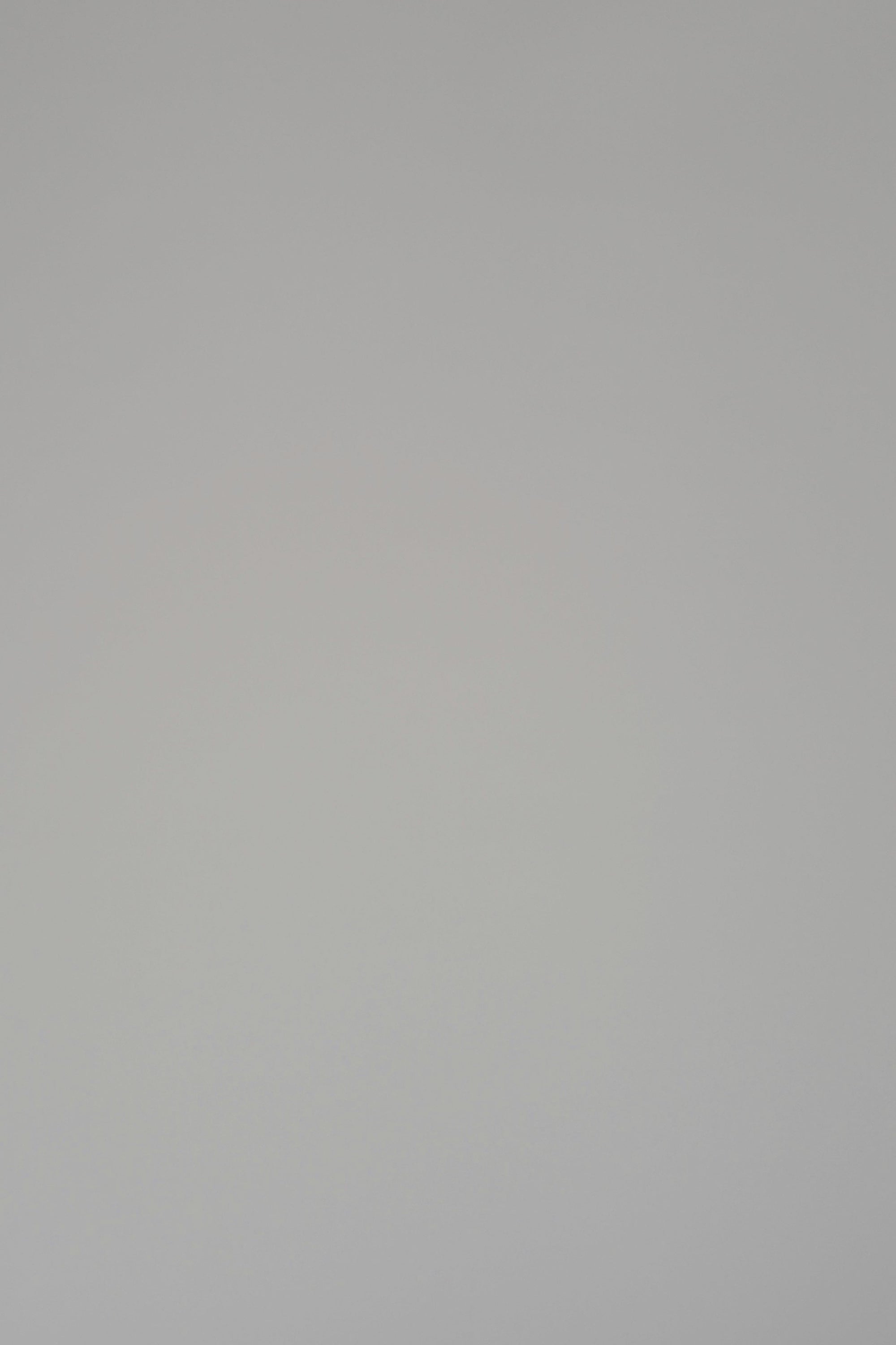 Woman modeling a white v-neck long sleeve sweater on a plain backdrop
