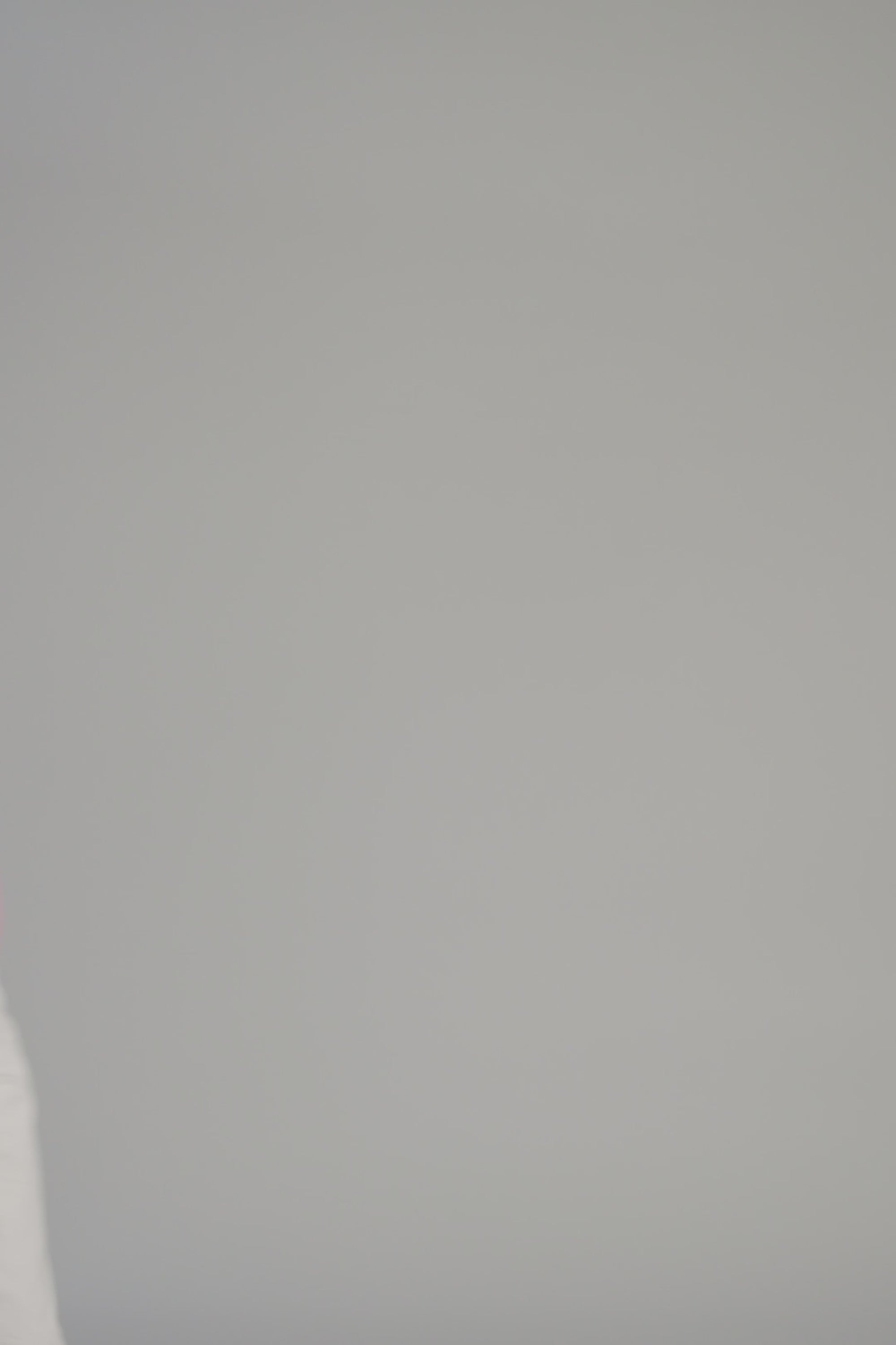 woman wearing a pink sweater with graphic on it on a white backdrop