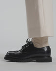 Close up video of navy shoes and cream pants on a white background