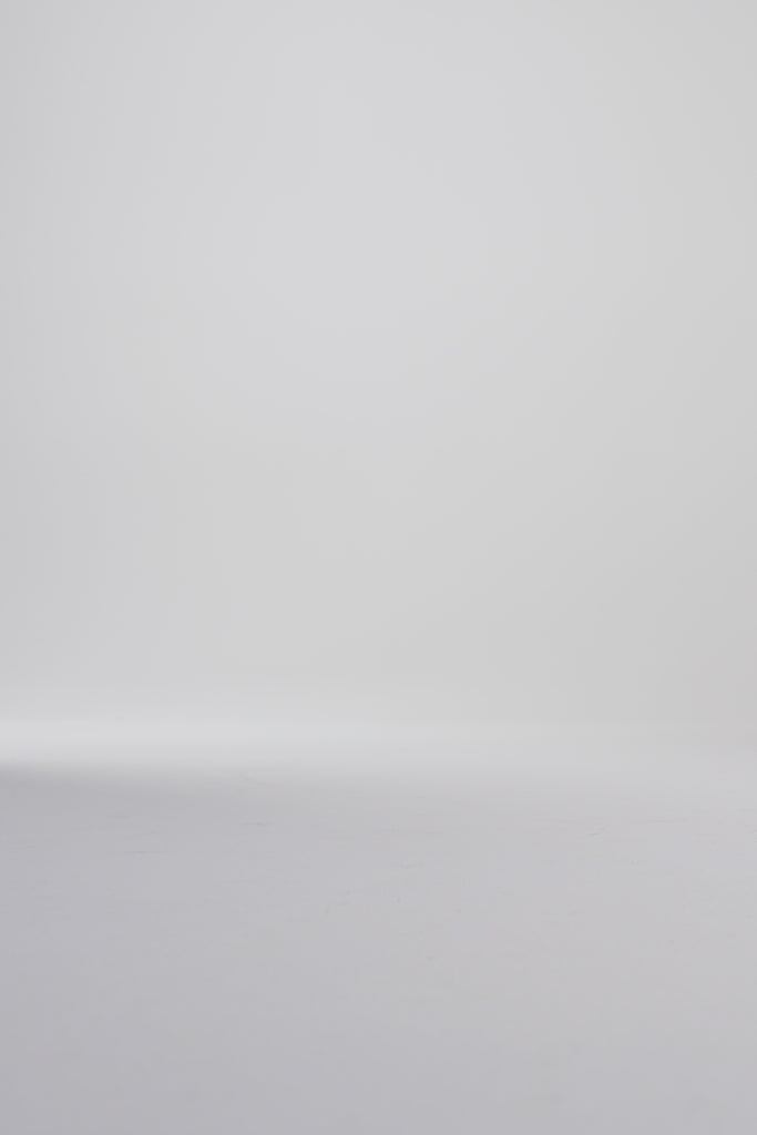 Woman modeling black oxford shoes on a white backdrop