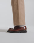 Woman modeling hazelnut derby shoes on a white backdrop